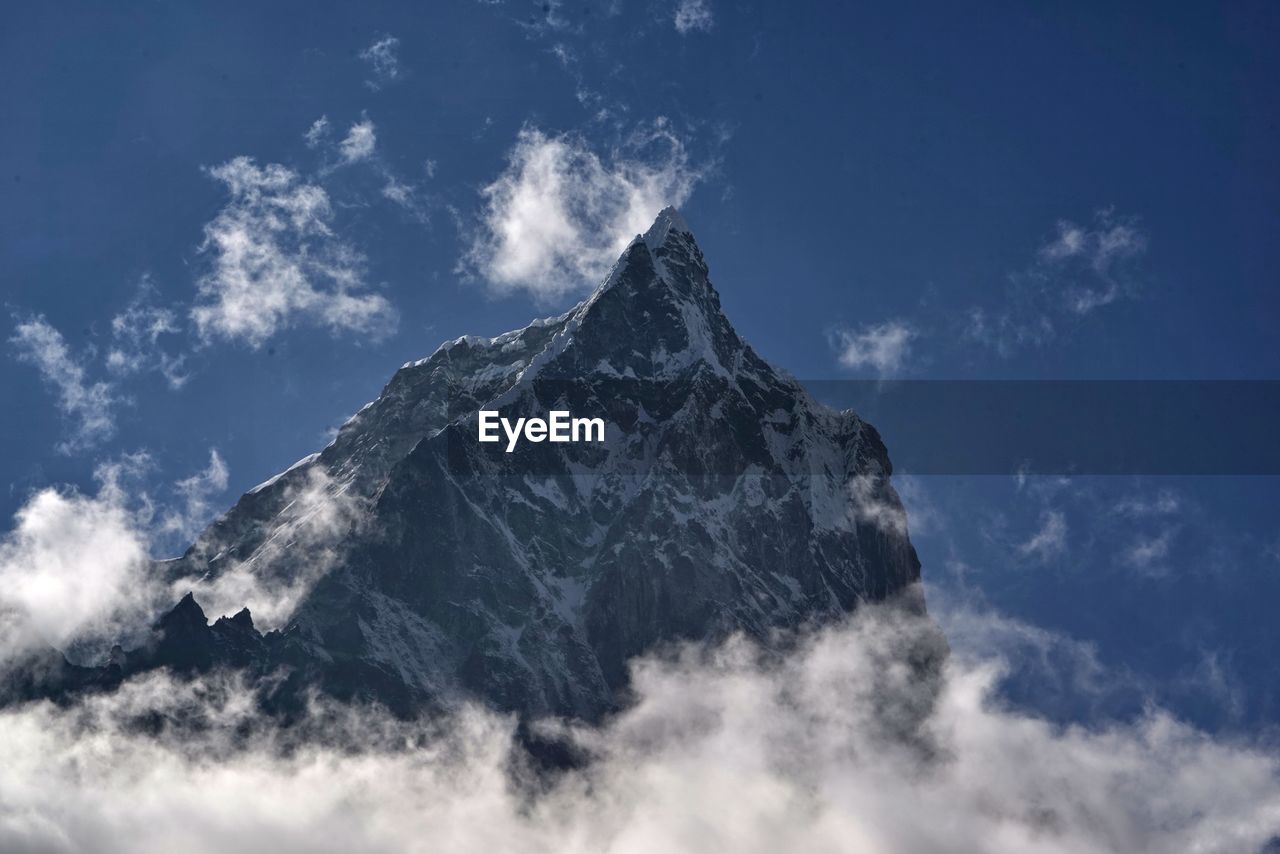 Low angle view of snowcapped mountains against sky