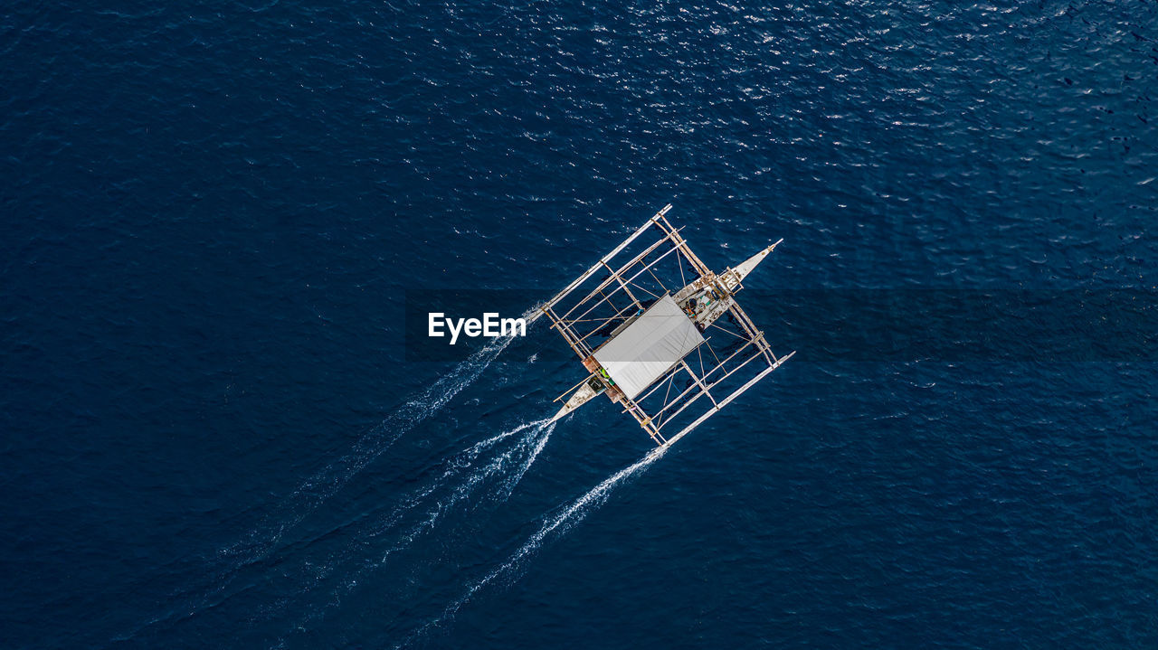 Aerial view of outrigger boat in sea