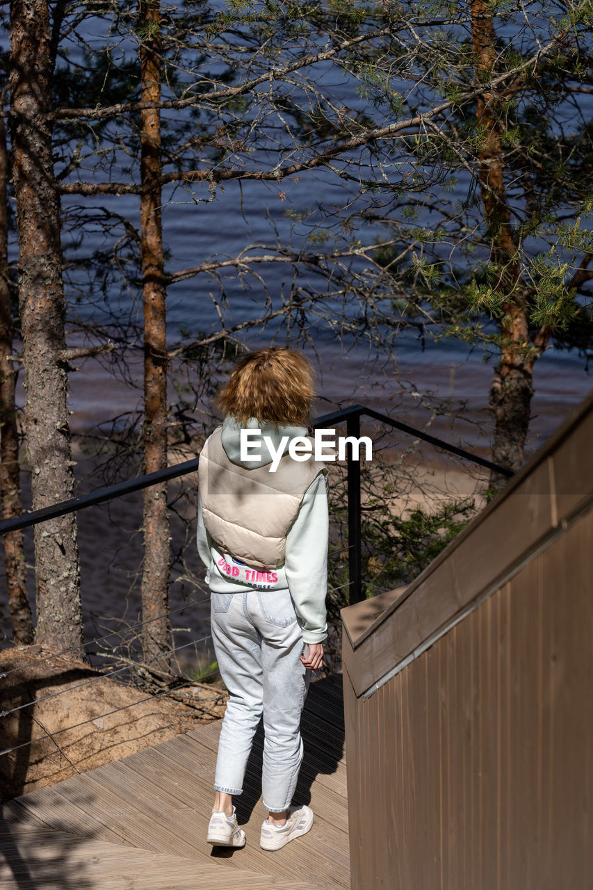 Rear view of woman standing by railing