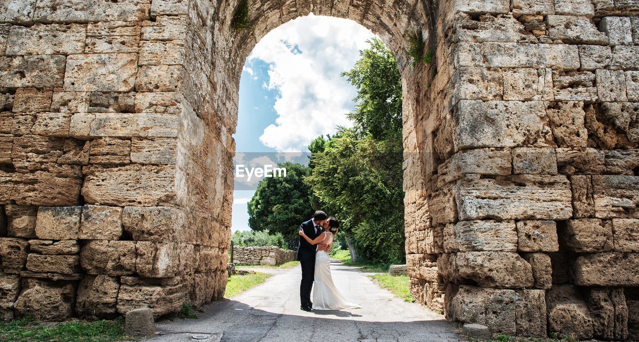 FULL LENGTH OF WOMAN PHOTOGRAPHING AT CAMERA