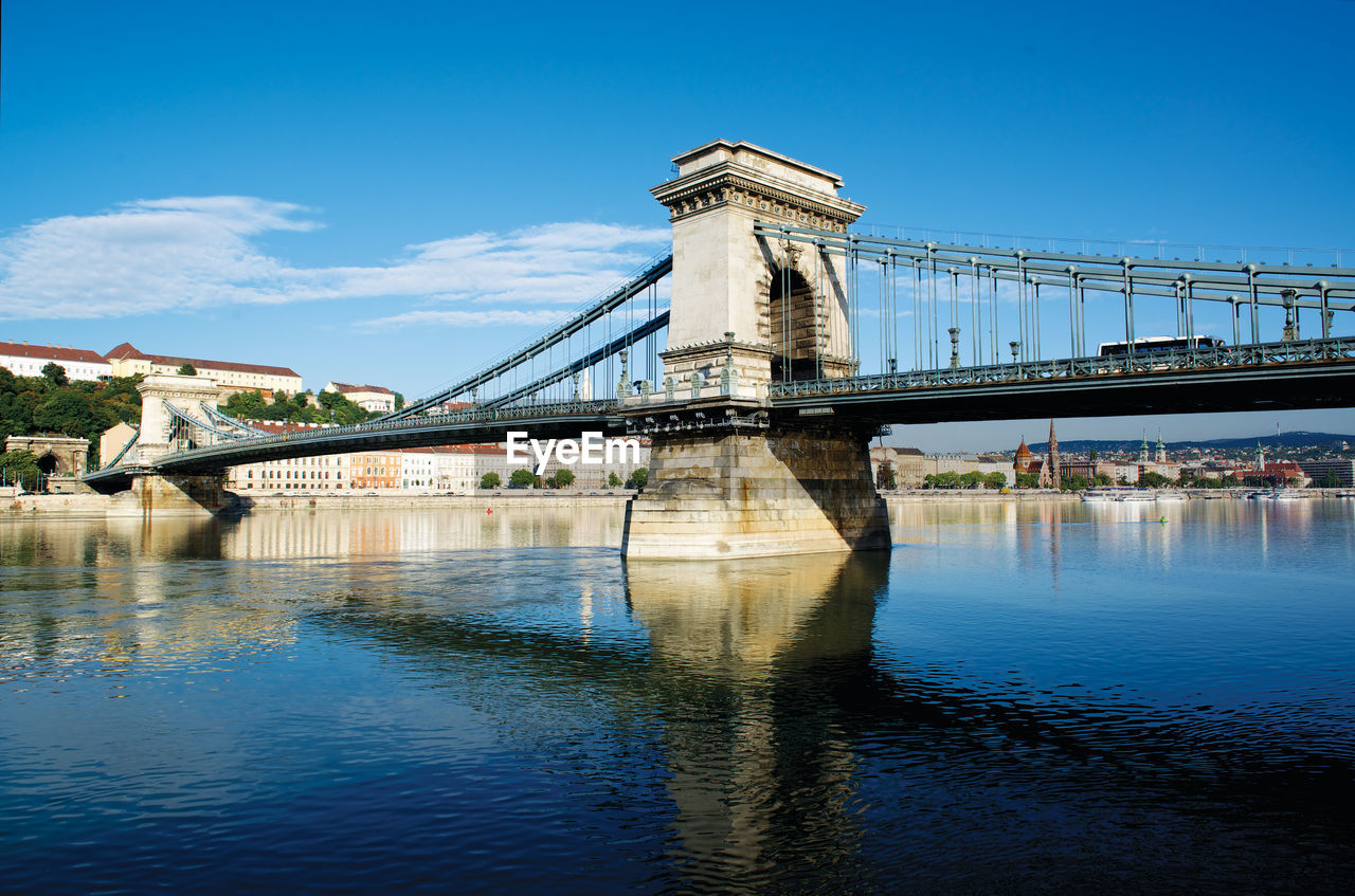 View of bridge over river against blue sky in budapest hungary