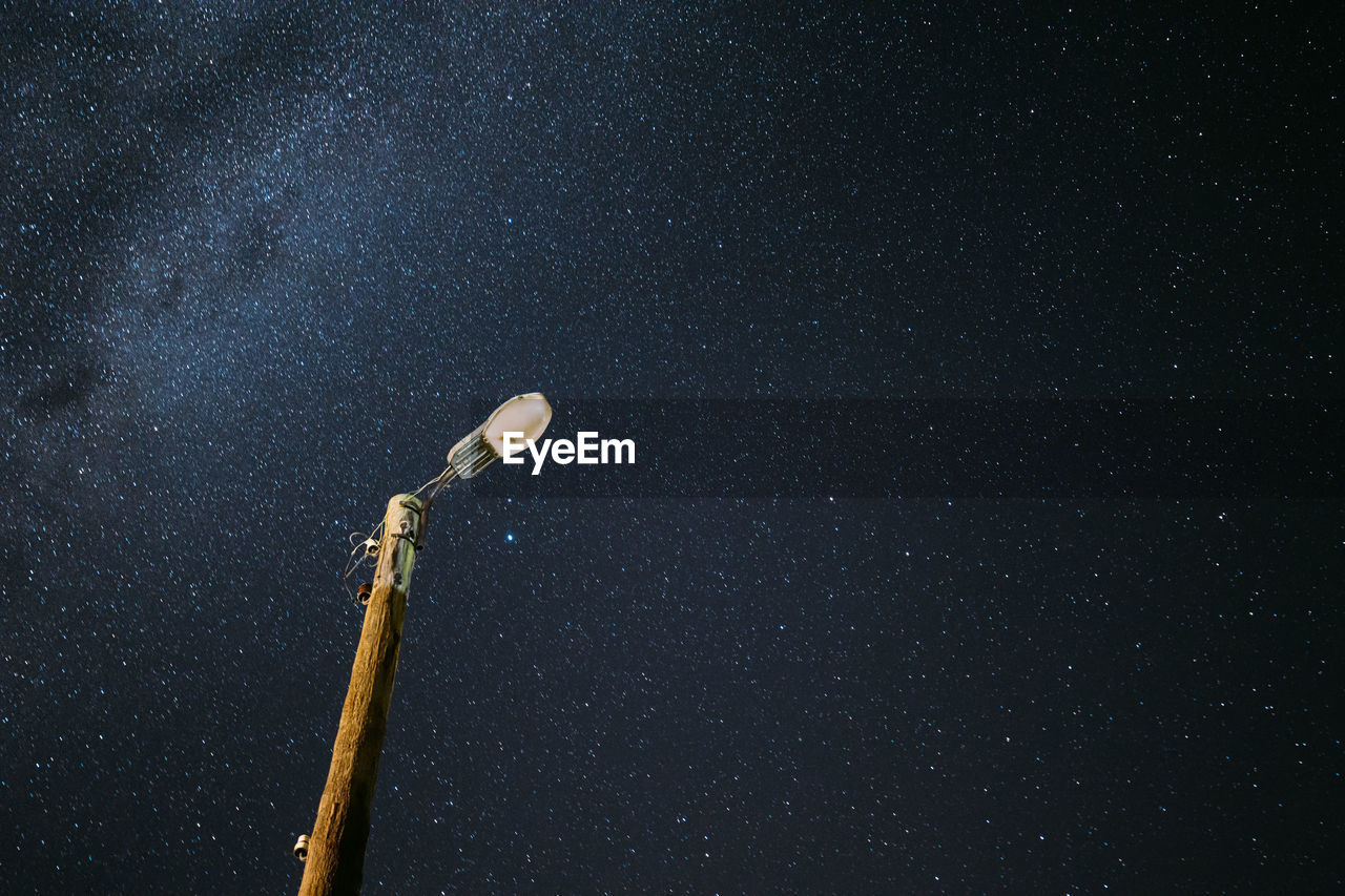 low angle view of illuminated light against sky at night