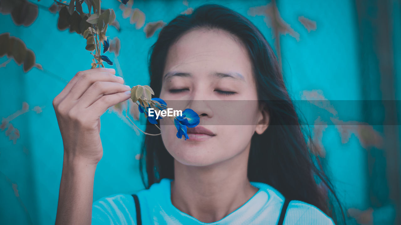 Close-up of woman smelling flower