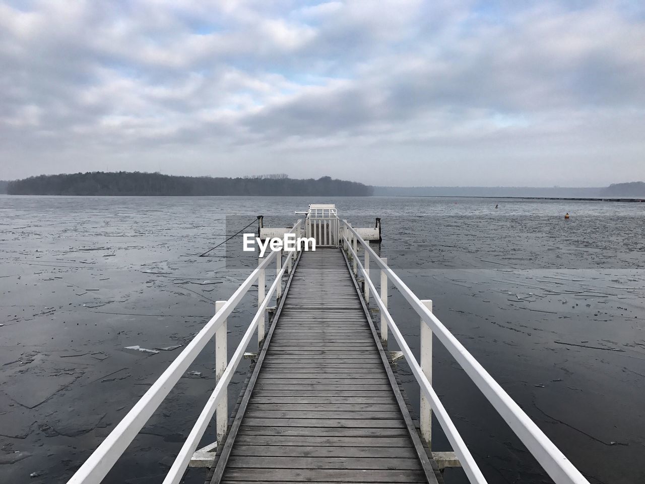 Jetty leading towards sea against sky