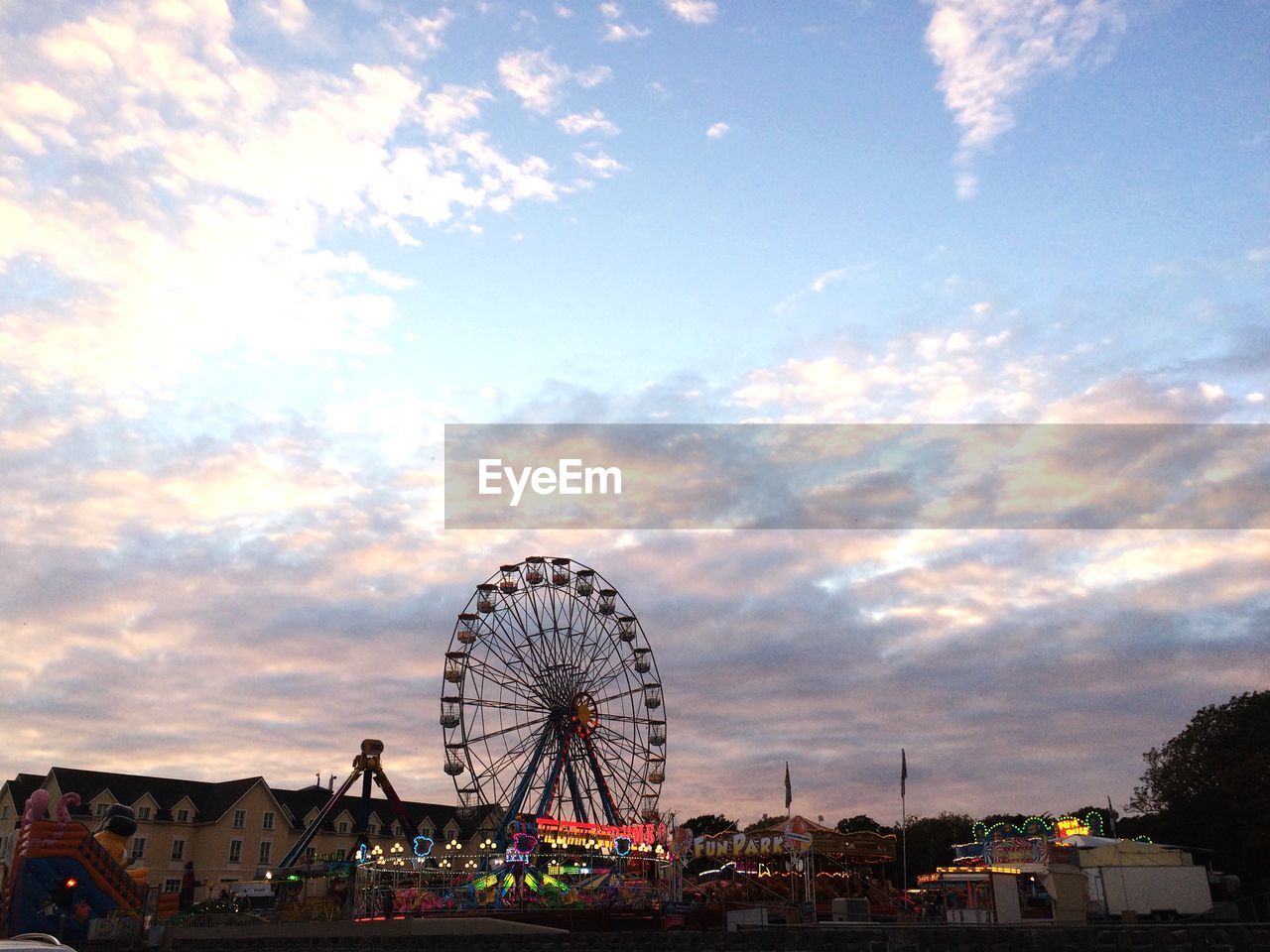 LOW ANGLE VIEW OF FERRIS WHEEL AGAINST CLOUDY SKY