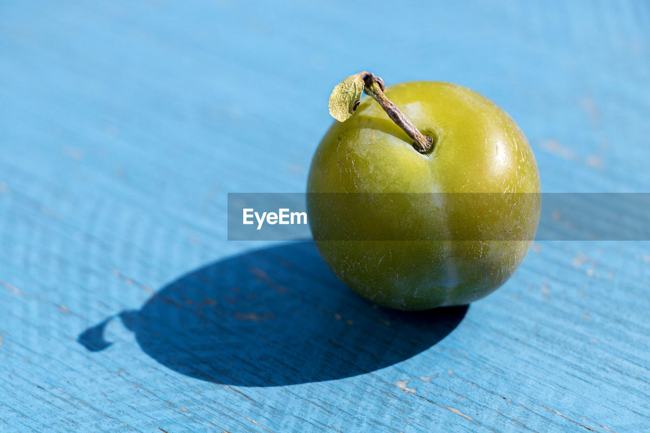 Close-up of aplum on a blue table