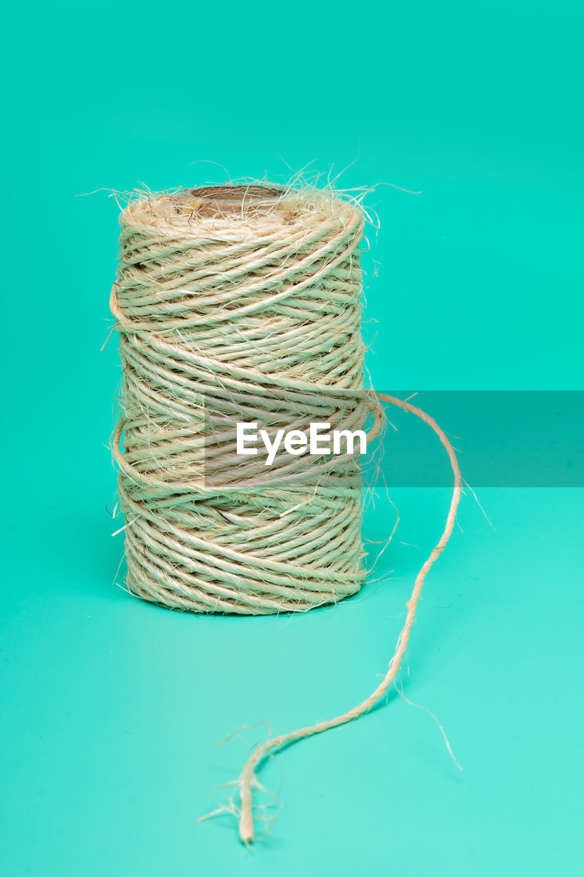 Close-up of twine over turquoise background