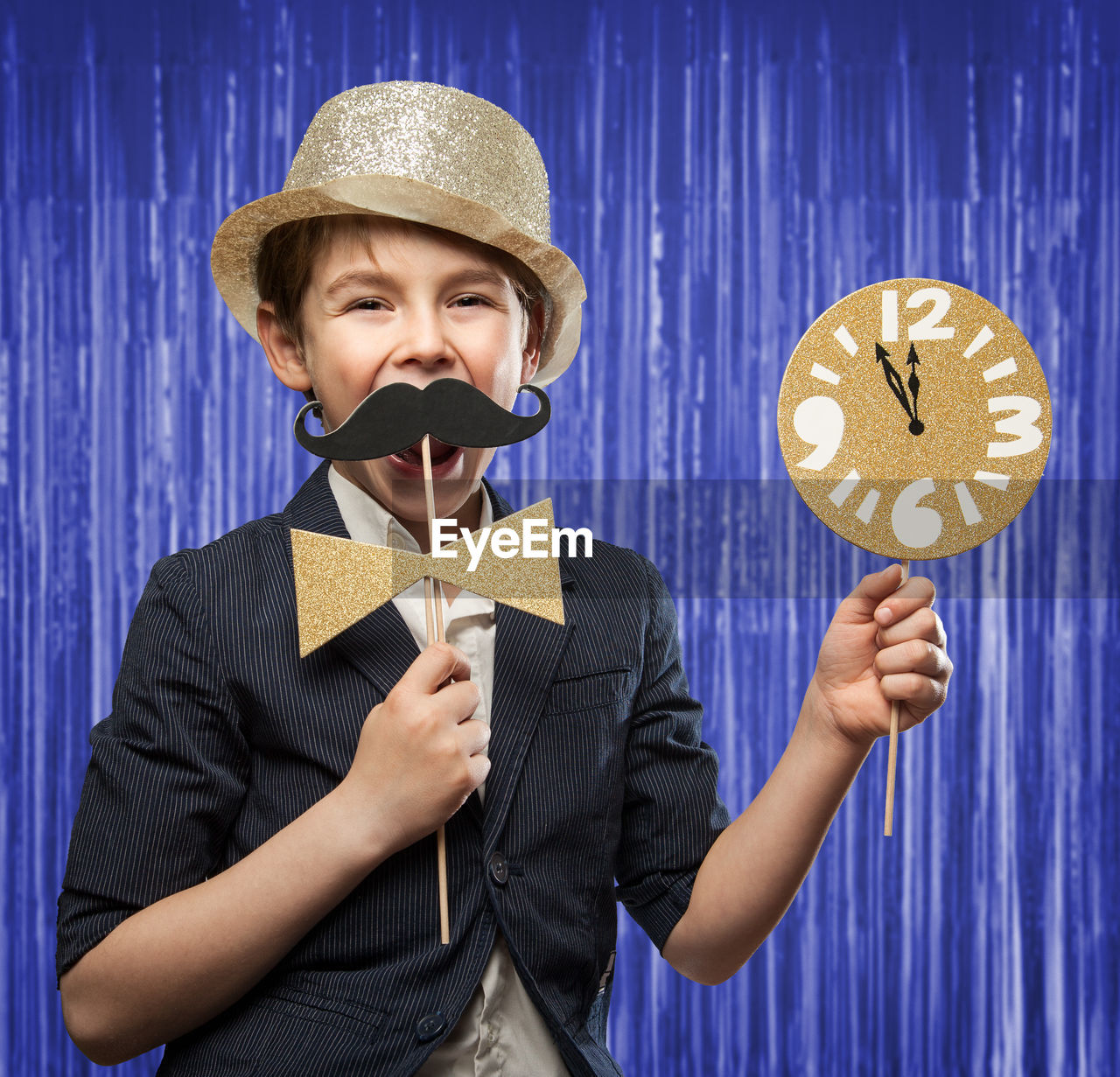 Portrait of smiling boy holding props