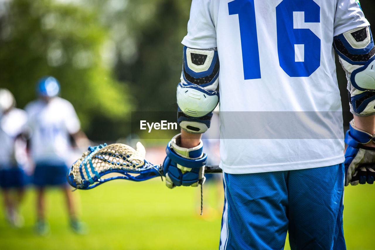 Midsection of sports person waking on soccer field