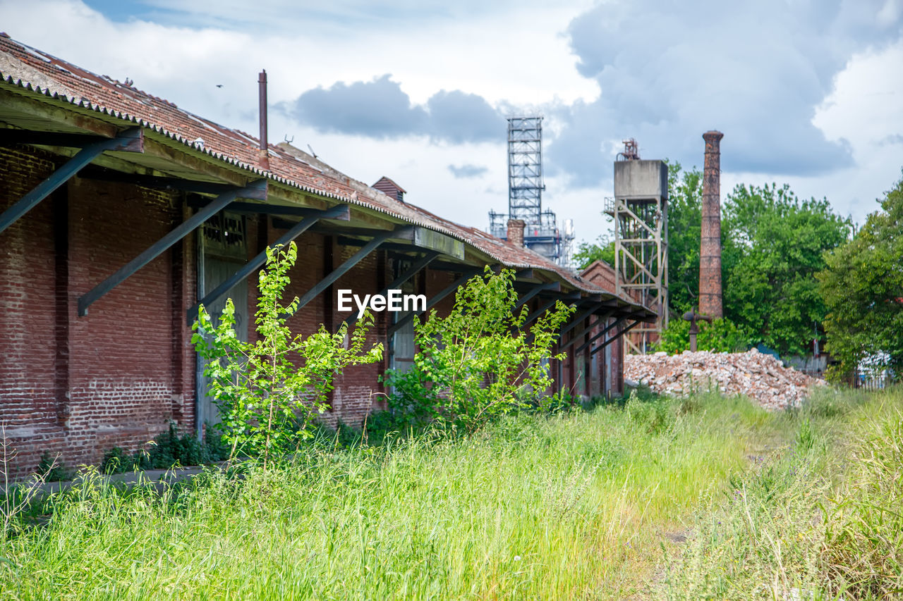 architecture, built structure, rural area, cloud, sky, plant, building exterior, grass, nature, building, landscape, house, rural scene, no people, industry, residential district, environment, tree, outdoors, green, history, transport, land, village, day, the past, old, travel destinations, field, business finance and industry