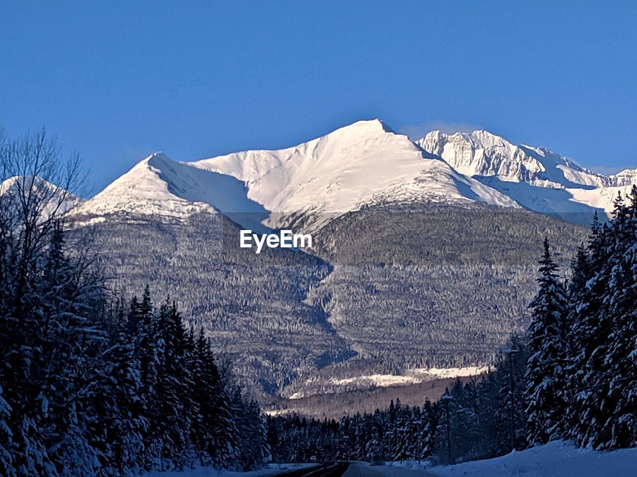 SNOW COVERED MOUNTAINS AGAINST CLEAR BLUE SKY