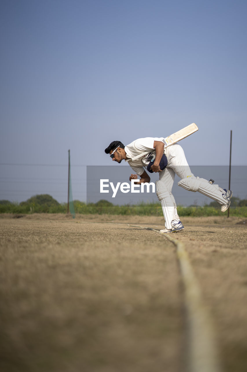 Young indian cricketer entering in the cricket field. indian cricket and sports concept.