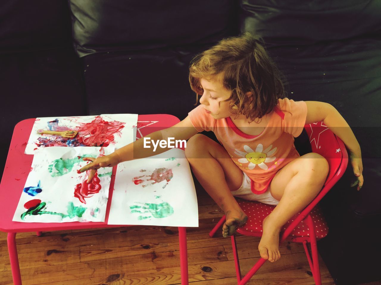 High angle view of cute girl painting on paper