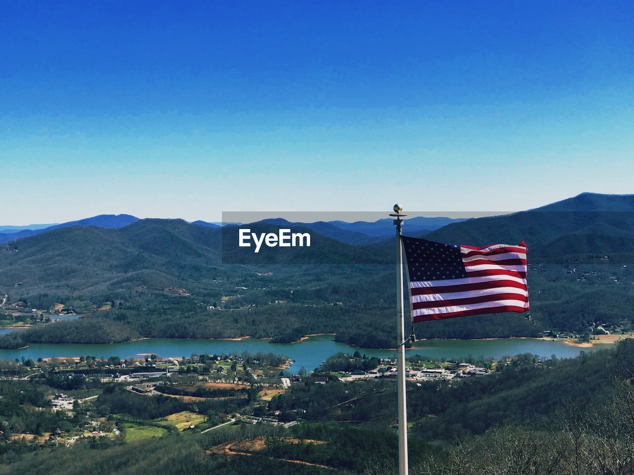 FLAGS ON LANDSCAPE AGAINST CLEAR BLUE SKY