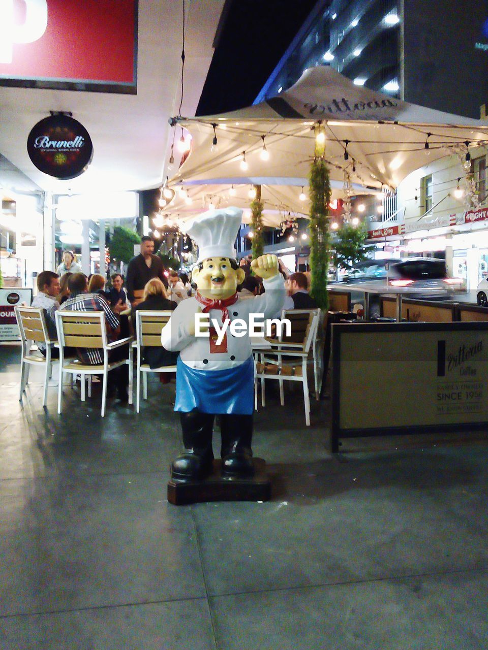 PEOPLE STANDING IN RESTAURANT WITH ILLUMINATED HOTEL