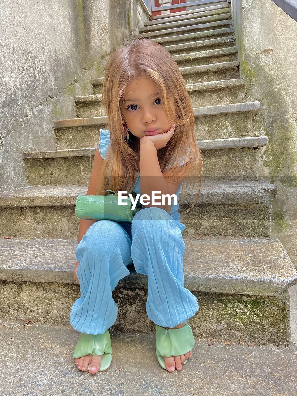 PORTRAIT OF A GIRL SITTING ON STAIRCASE