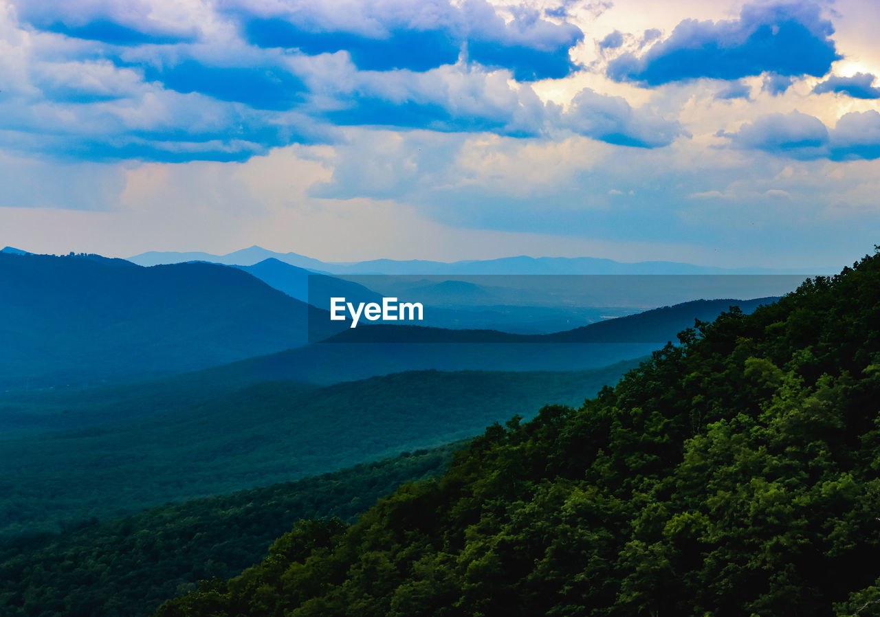 environment, mountain, landscape, scenics - nature, sky, cloud, nature, beauty in nature, land, tree, mountain range, forest, plant, tranquility, travel, no people, tranquil scene, fog, outdoors, travel destinations, non-urban scene, blue, valley, tourism, morning, idyllic, wilderness, summer, dramatic sky, green, social issues, sunlight, cloudscape, horizon, mountain peak, sun, plateau, high angle view, highland, rural scene, trip, vacation, twilight, water, pinaceae