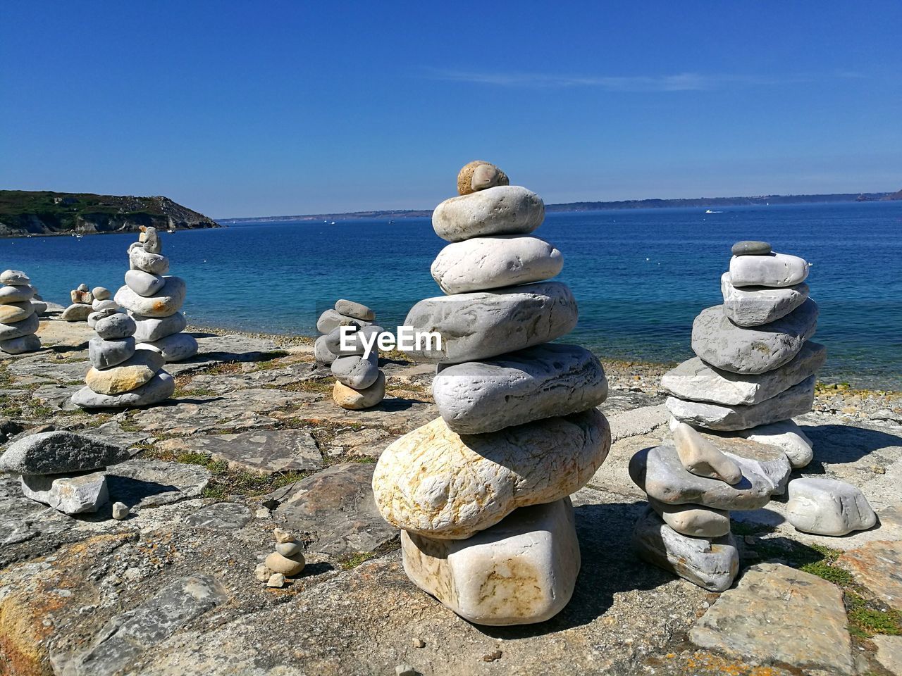 STACK OF PEBBLES ON BEACH AGAINST SKY