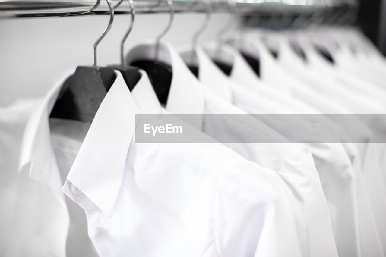 CLOSE-UP OF CLOTHES HANGING ON RACK