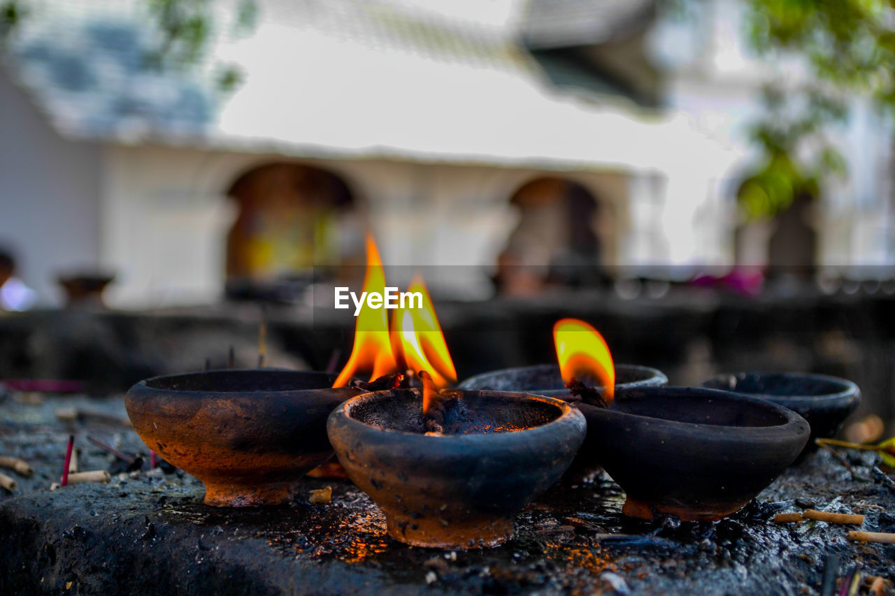 CLOSE-UP OF LIT CANDLES IN TEMPLE