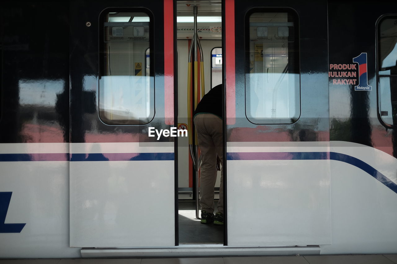 MIDSECTION OF MAN IN TRAIN