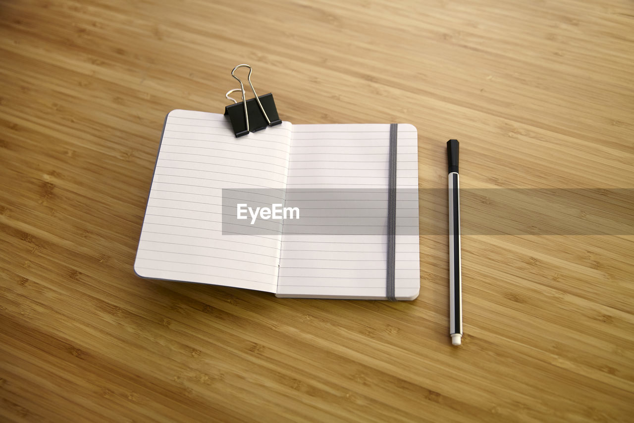 High angle view of book and pen on table