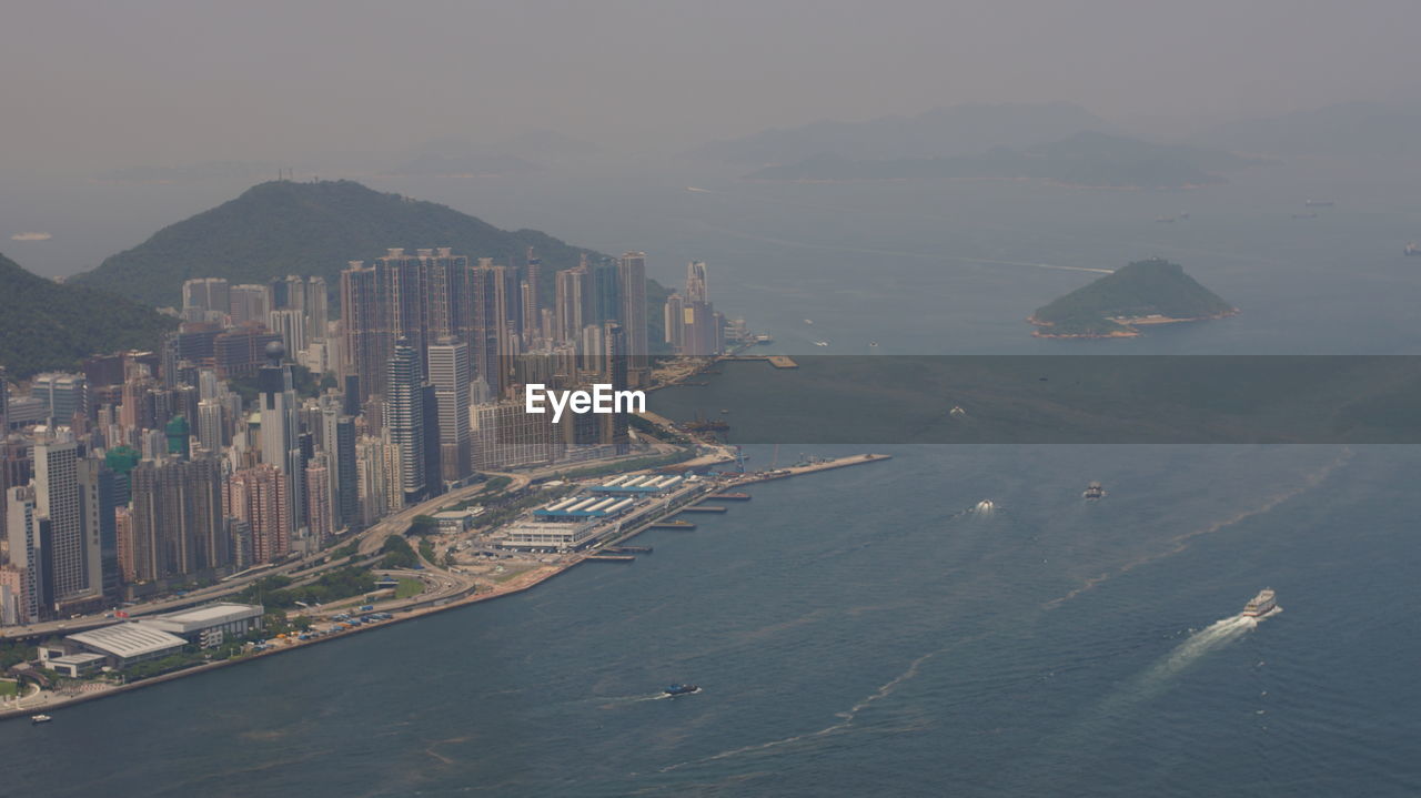 HIGH ANGLE VIEW OF SEA AND MODERN BUILDINGS AGAINST SKY