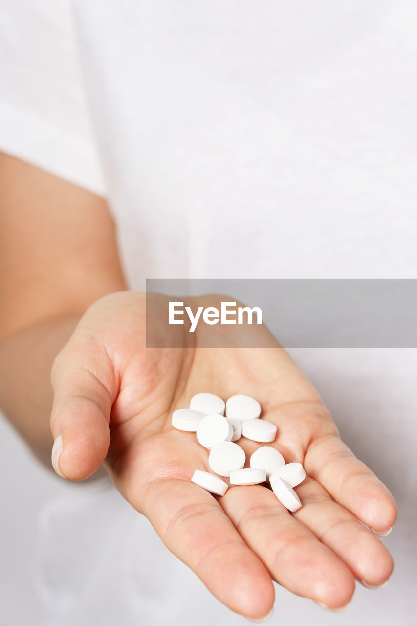 cropped hand of person holding pills