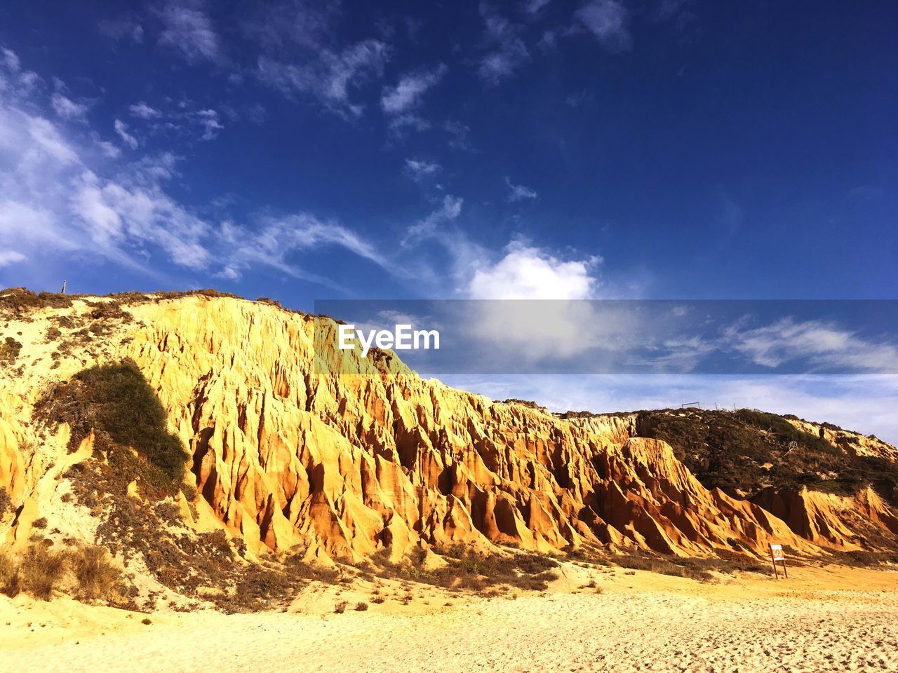 Scenic view of rocky mountains against blue sky