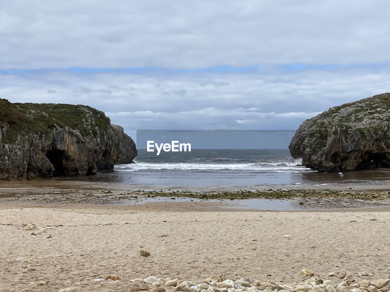 Rock formation on beach against sky