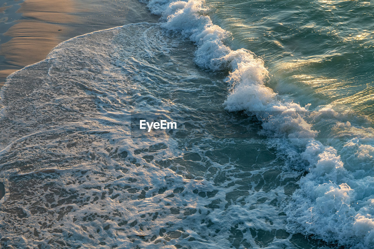 High angle view of waves rushing towards shore