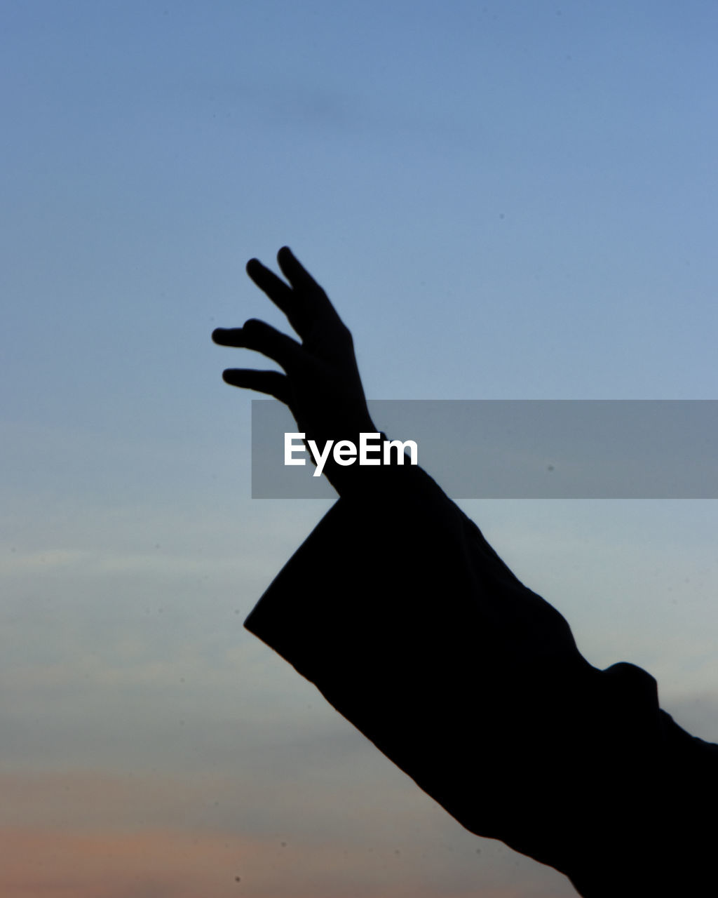 Cropped image of silhouette hand against clear sky