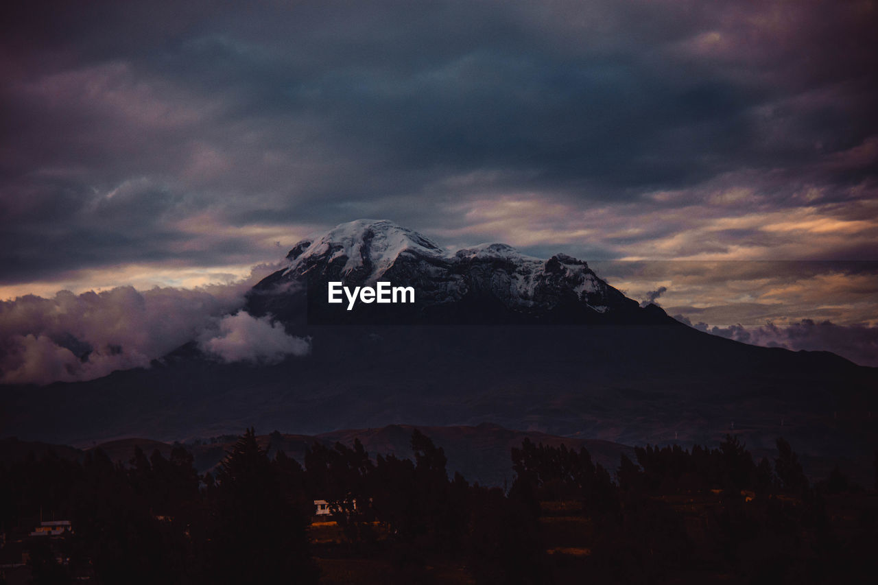 Scenic view of silhouette mountains against dramatic sky