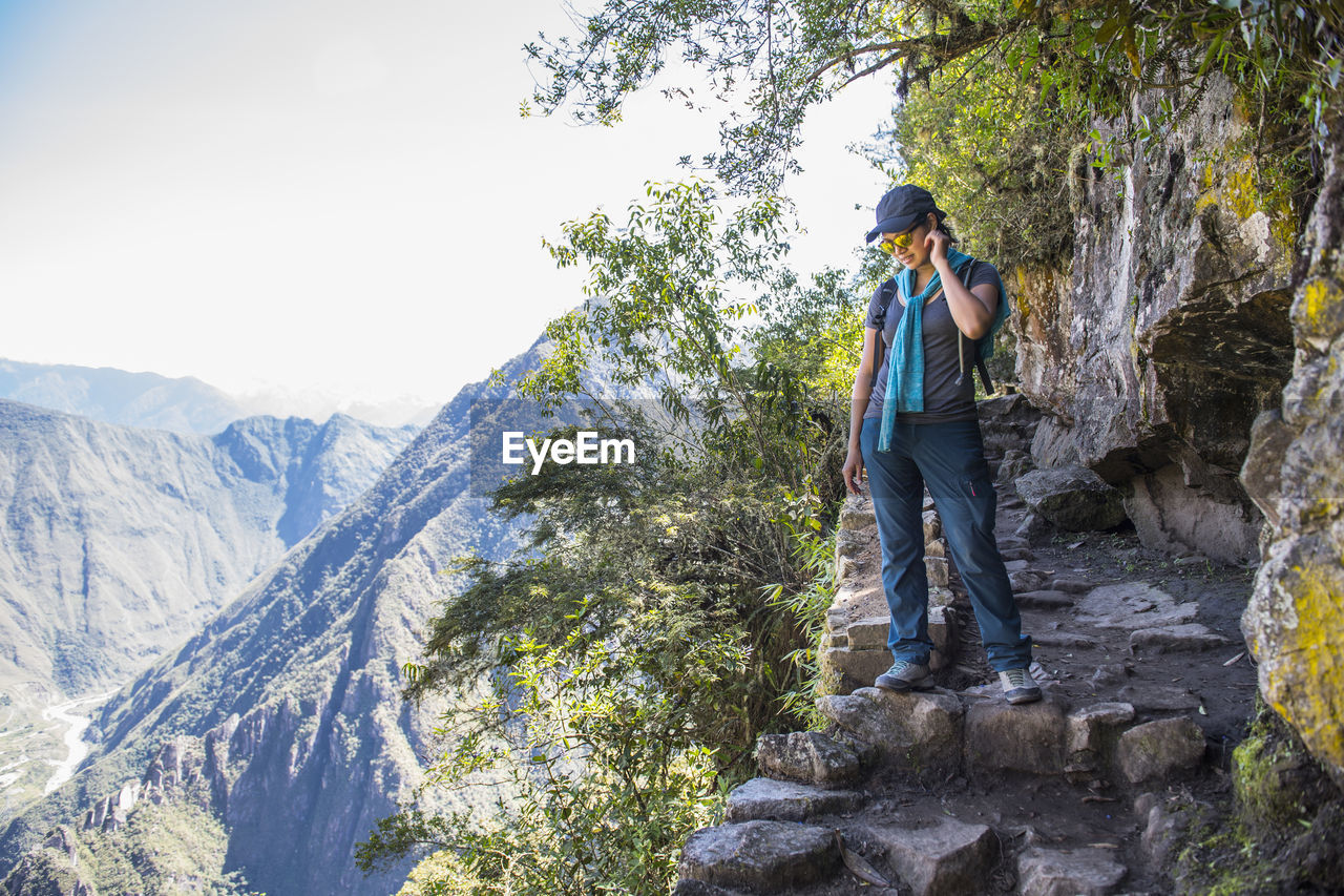 Woman looking down from inca trail path close to machu picchu,