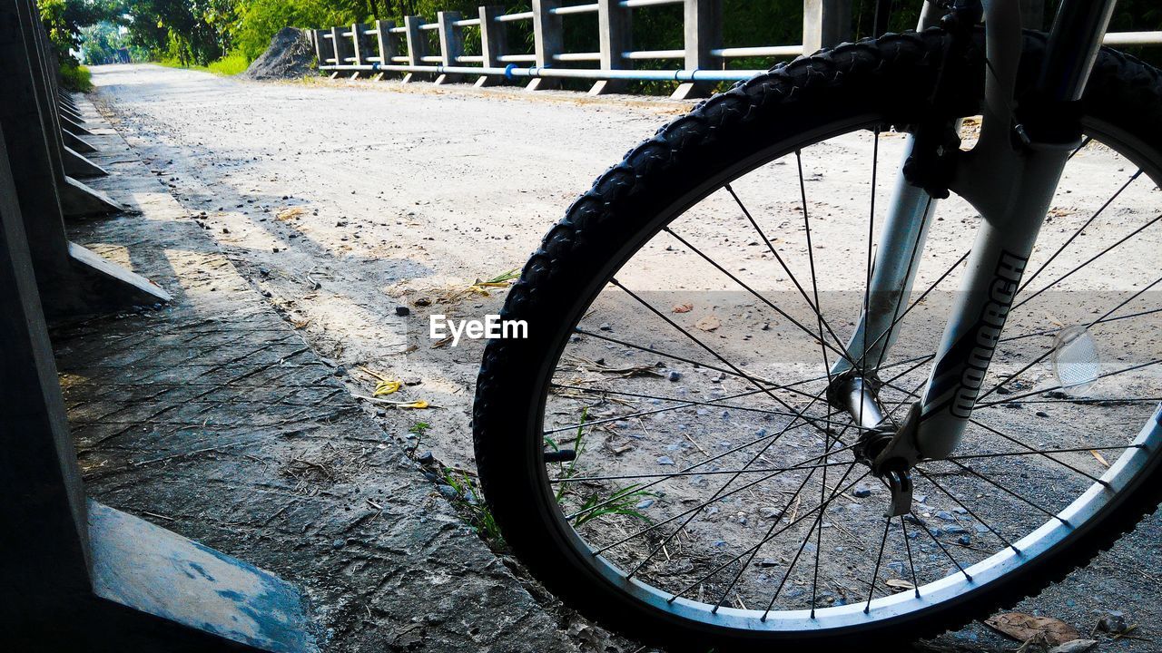 Cropped image of bicycle parked on bridge