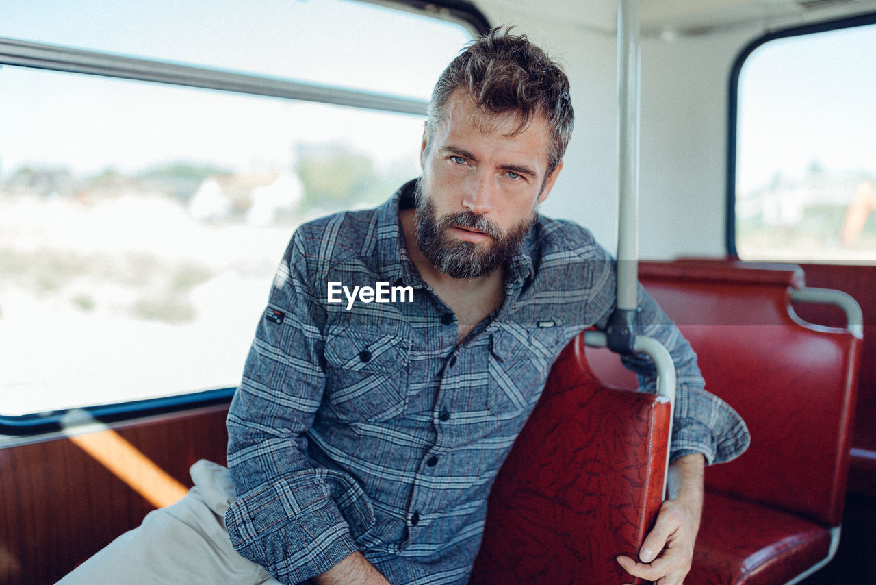 PORTRAIT OF MAN SITTING IN BUS