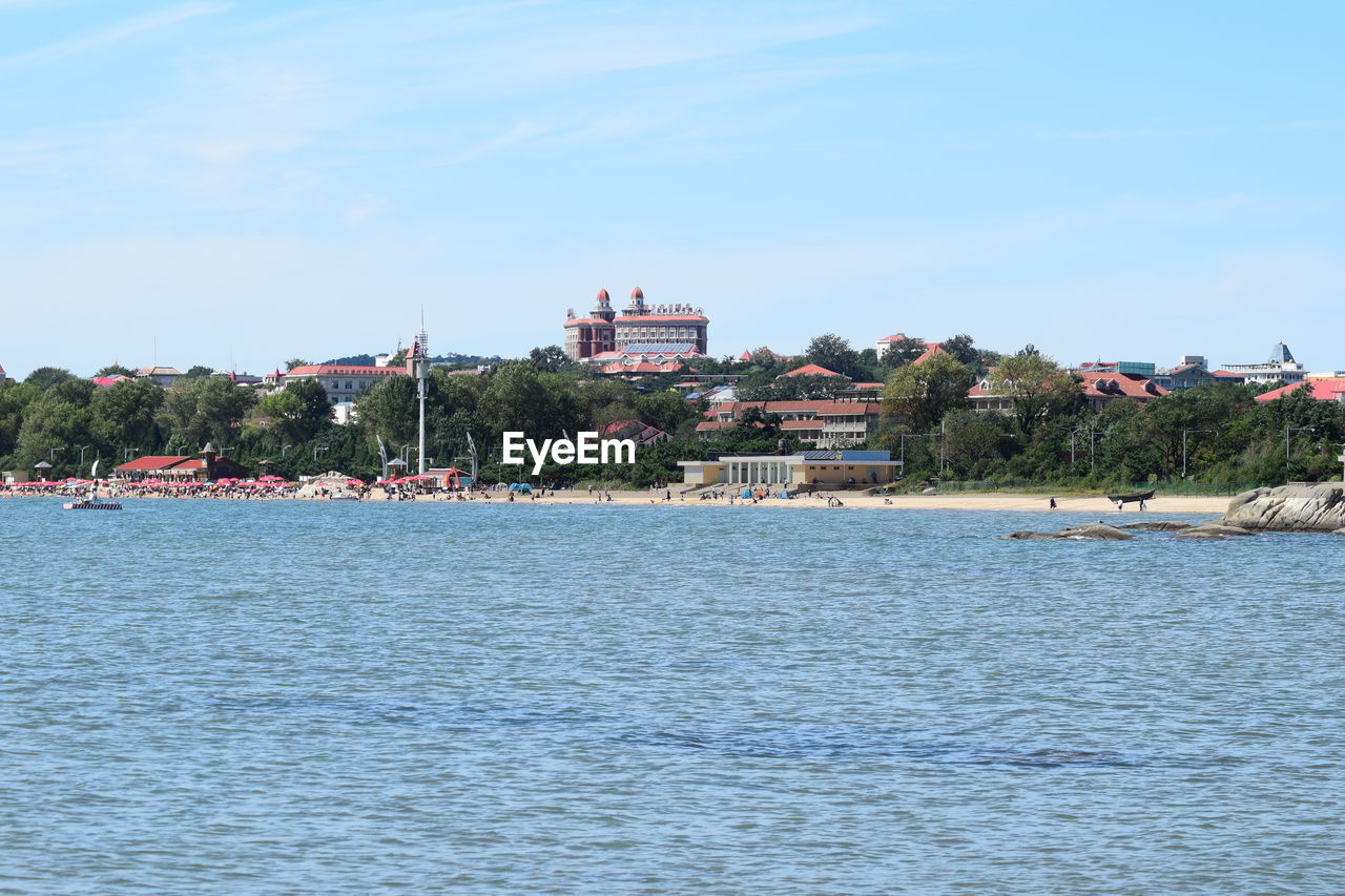 Scenic view of sea by buildings against sky