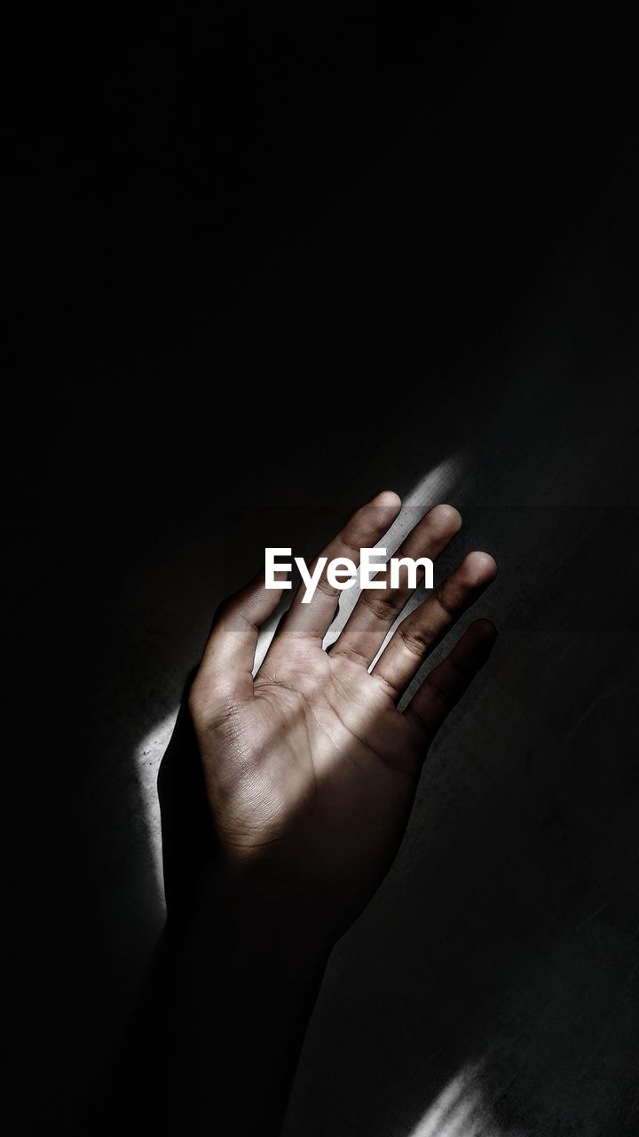 Close-up of person hand against black background