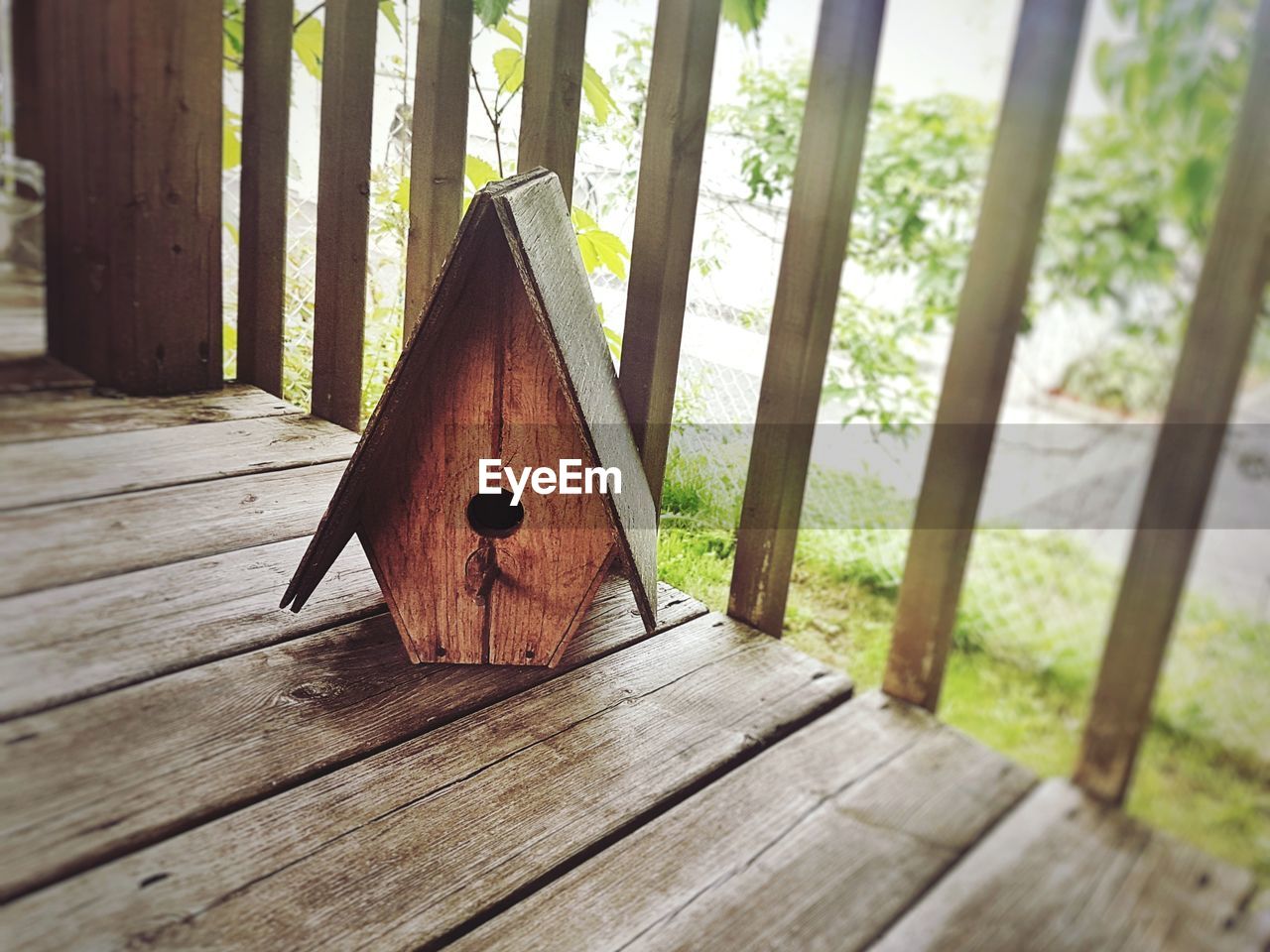 Close-up of birdhouse on wooden deck