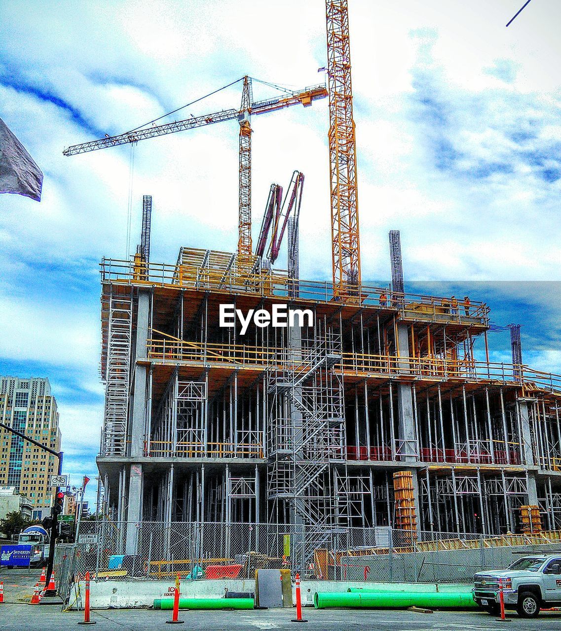 LOW ANGLE VIEW OF CRANES AGAINST SKY