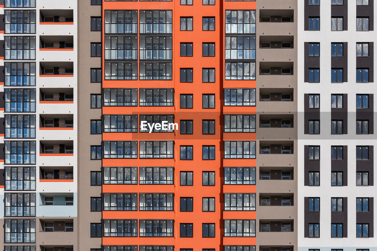 Full frame background of new high rise apartament building wall with multiple balcony and windows