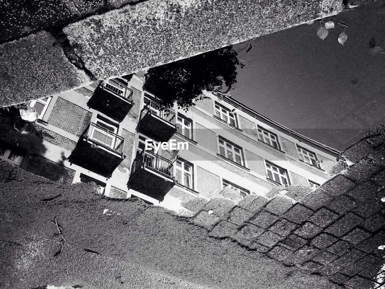 Reflection of apartment building in puddle