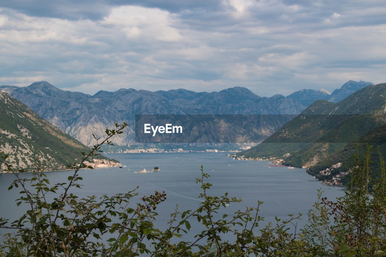 Scenic view of lake by mountains against sky