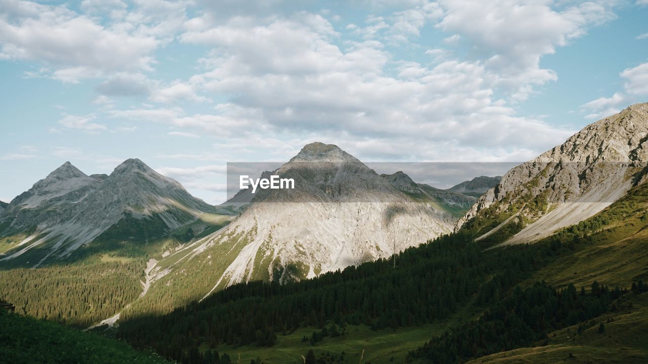 Scenic view of mountains against cloudy sky