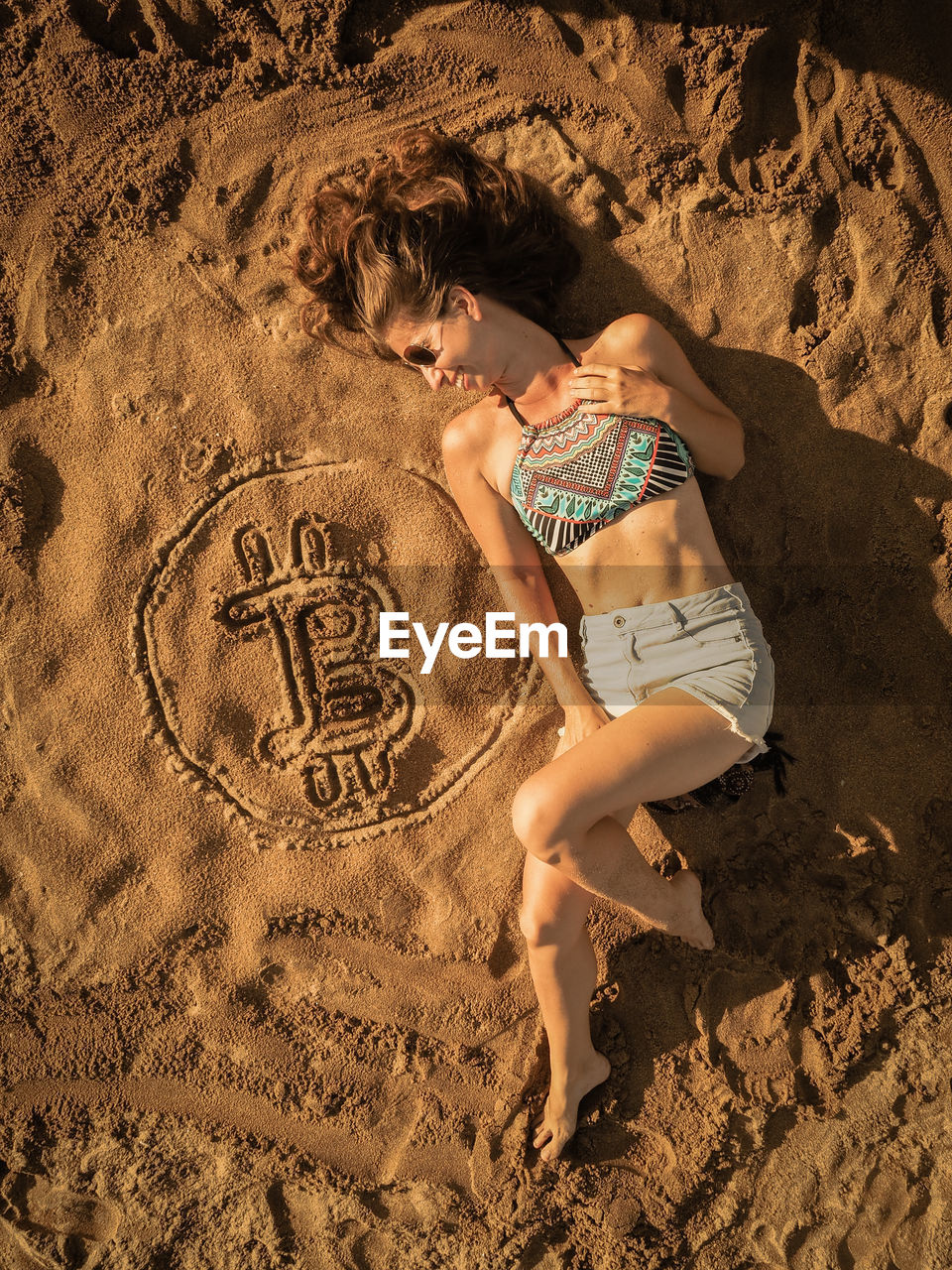 FULL LENGTH OF YOUNG WOMAN ON SAND
