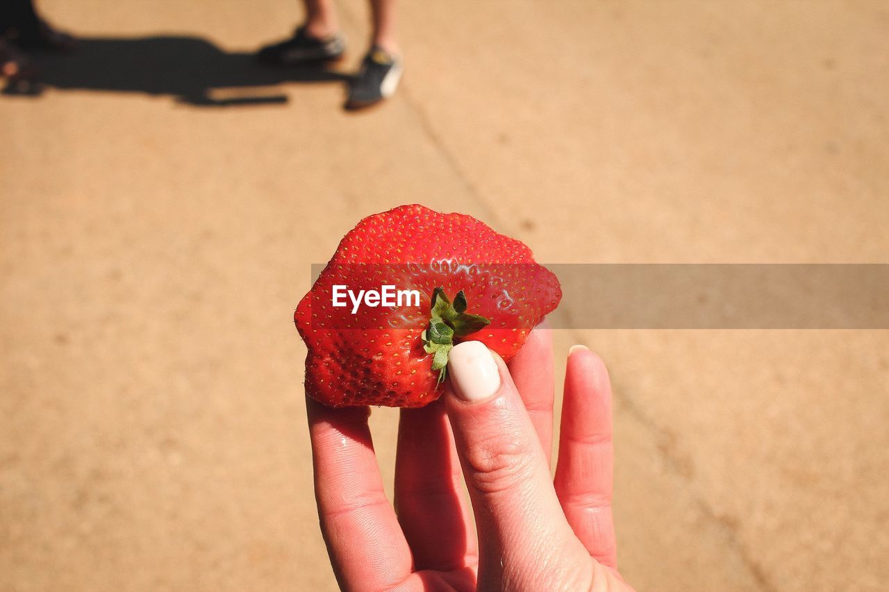 Close-up of hand holding strawberry