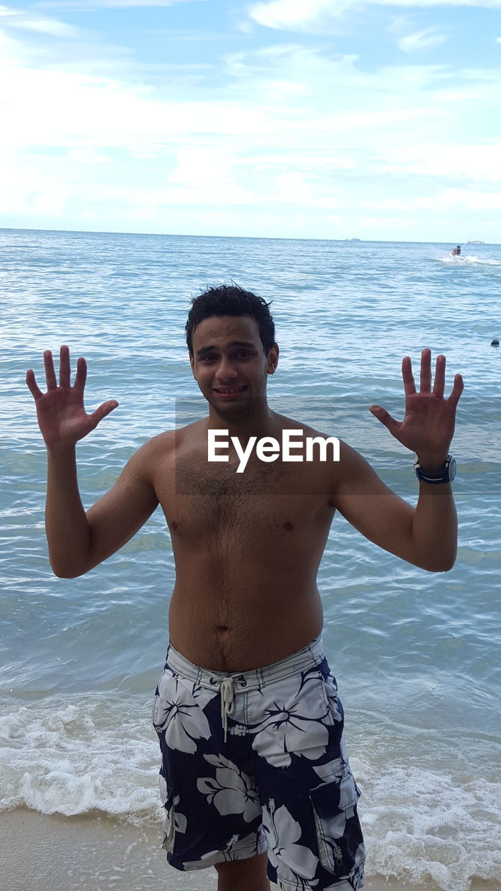 PORTRAIT OF YOUNG MAN STANDING IN SEA