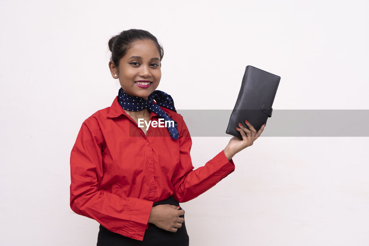 SMILING YOUNG WOMAN USING SMART PHONE
