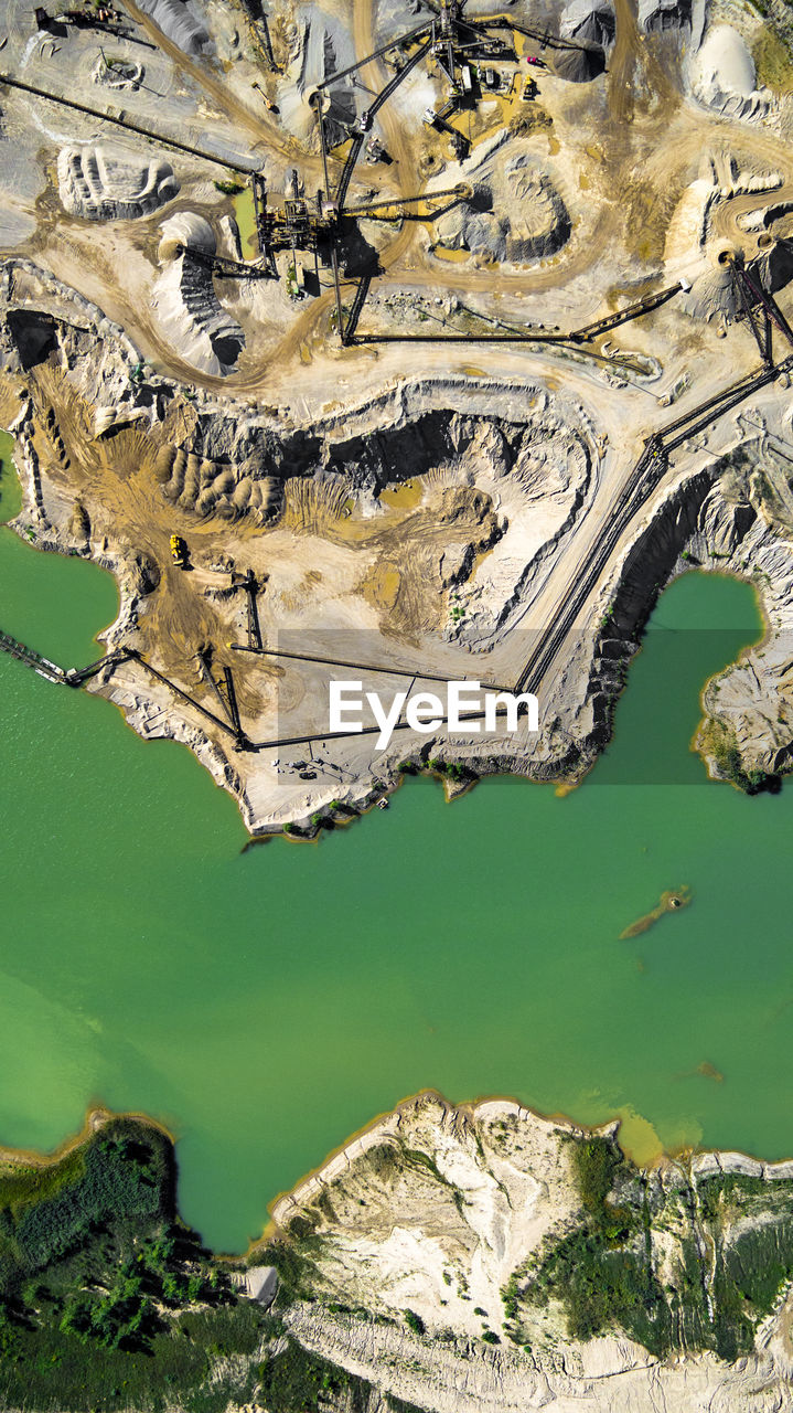 High angle view of coal mine by river on sunny day