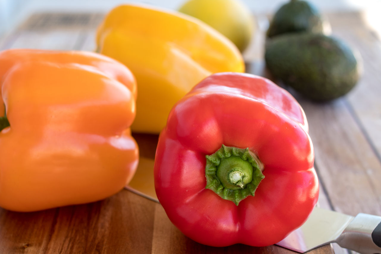 CLOSE-UP OF RED BELL PEPPERS AND TABLE